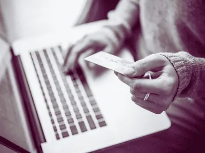 woman typing her card details into a laptop