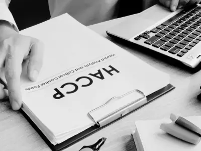 Black and white photograph of a HACCP certificate food safety document on a desk